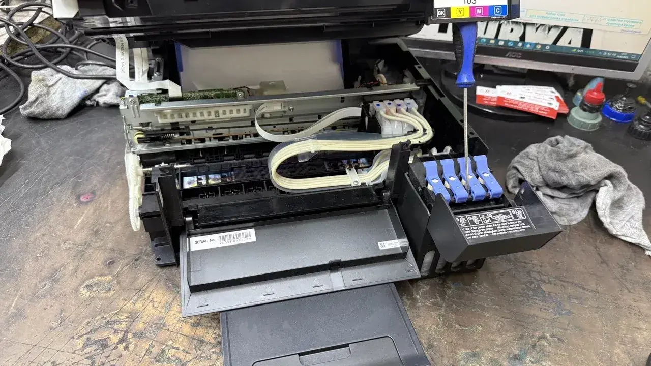 Epson czyszczenie głowicy automatyczne. Widać wnętrze drukarki, tusze i śrubokręt.