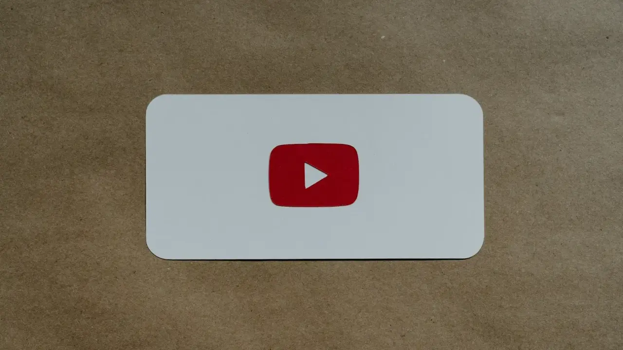 Biała karta z czerwonym logo YouTube, symbolem odtwarzania, który nie jest wtyczką do łapek w dół.