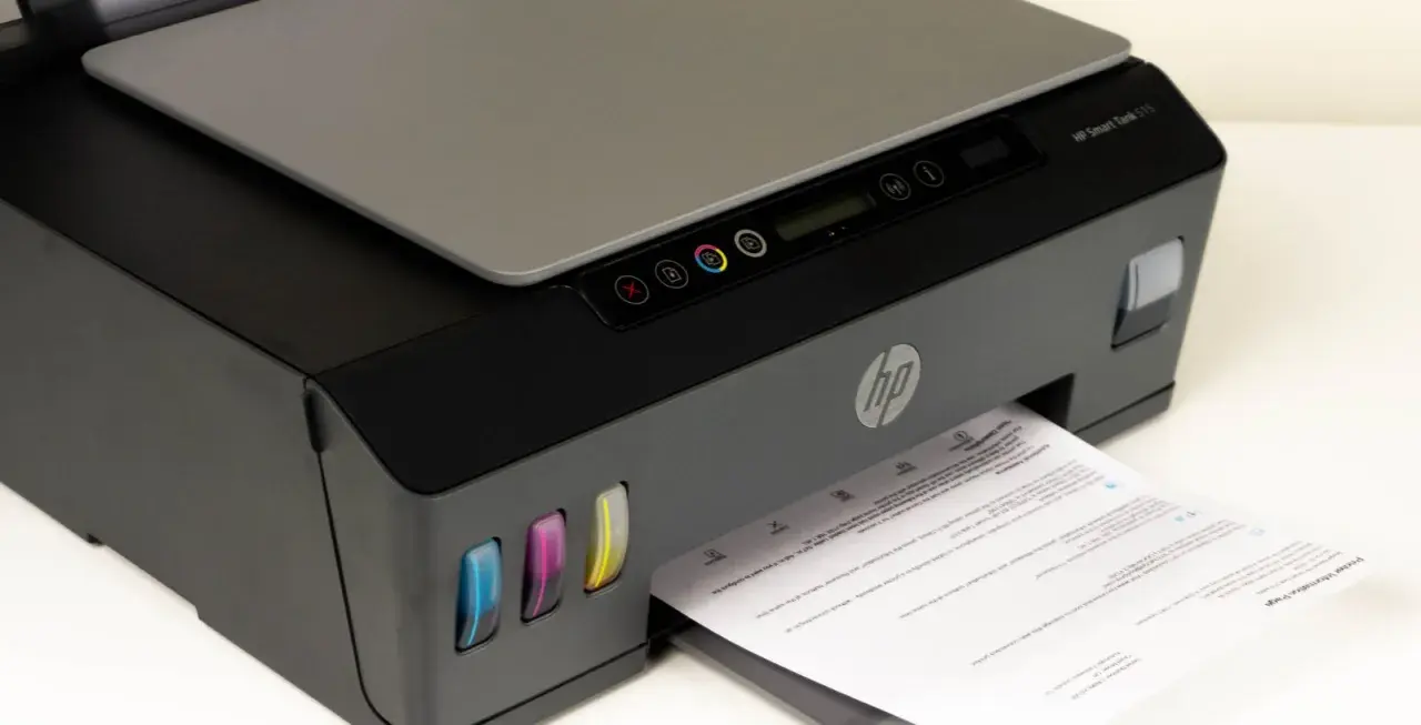 Drukarka HP Smart Tank 515, widoczne kolorowe zbiorniki z tuszem i wychodzący papier. Czas na czyszczenie głowicy, by wydruki były idealne.