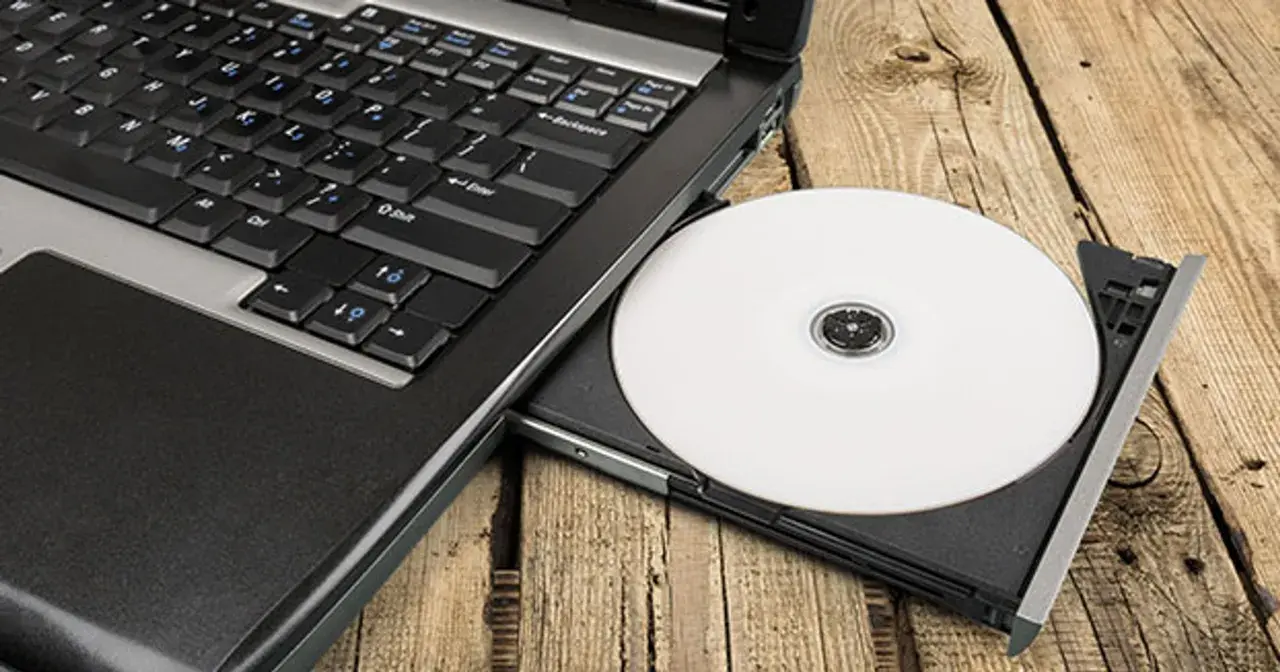 Laptop z wysuniętym napędem CD, na którym leży biała płyta. Idealne do nagrywania z cdburnerxp portable.