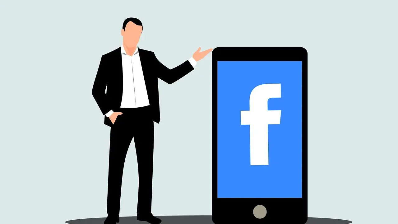 Mężczyzna w garniturze obok telefonu z logo Facebook. Dowiedz się, jak usunąć rolki z Facebooka.