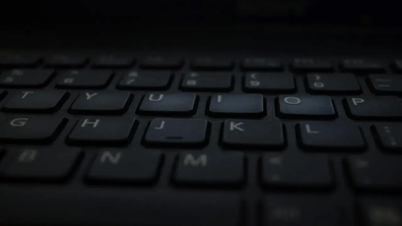 Klawiatura laptopa, gotowa do pisania głosowego w Word. Litery T, Y, U, I, O, P, G, H, J, K, L, B, N, M widoczne.