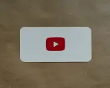 Biała karta z czerwonym logo YouTube, symbolem odtwarzania, który nie jest wtyczką do łapek w dół.