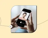 Dłonie trzymają smartfon z aplikacją do robienia zdjęć z efektami. Na ekranie widać portret kobiety i narzędzia edycji.