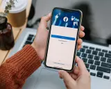 Osoba loguje się na Facebooku na telefonie. Widok ekranu logowania FB z polami na numer telefonu/email i hasło.