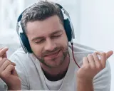 Mężczyzna w słuchawkach cieszy się muzyką. Zastanawiasz się aimp co to? To popularny odtwarzacz muzyki.
