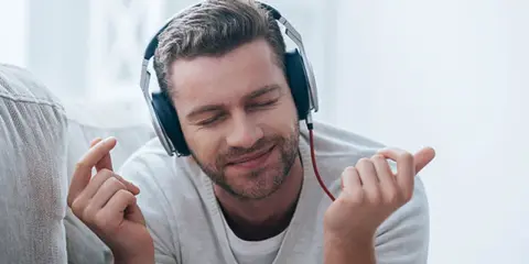 Mężczyzna w słuchawkach cieszy się muzyką. Zastanawiasz się aimp co to? To popularny odtwarzacz muzyki.
