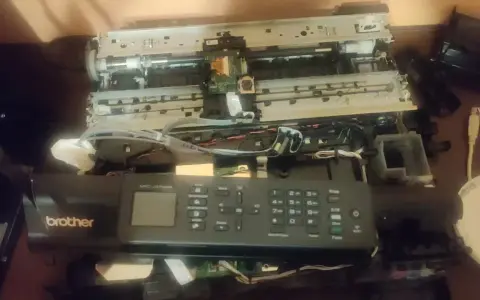 Rozłożona drukarka Brother MFC-J470DW, być może z powodu błędu 48. Widoczne wnętrze, płytki drukowane i kable.