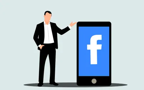 Mężczyzna w garniturze obok telefonu z logo Facebook. Dowiedz się, jak usunąć rolki z Facebooka.