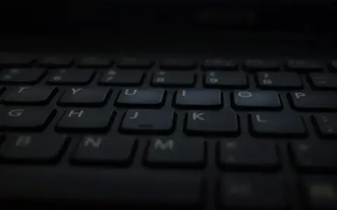Klawiatura laptopa, gotowa do pisania głosowego w Word. Litery T, Y, U, I, O, P, G, H, J, K, L, B, N, M widoczne.