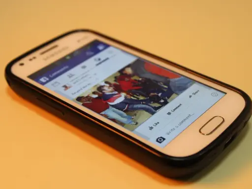 Smartfon z Facebookiem. Widoczna galeria zdjęć, przyciski "Lubię to", "Komentarz", "Udostępnij". Maksymalny rozmiar filmu na FB jest tu kluczowy.