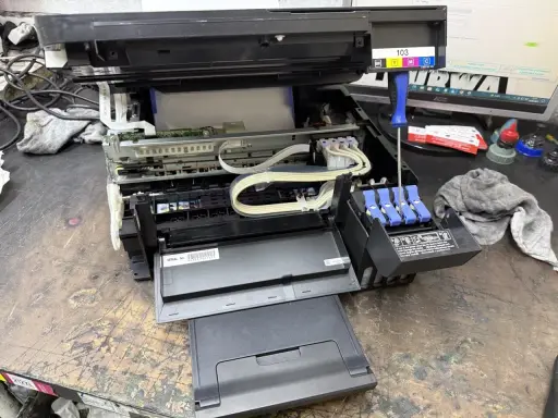 Epson czyszczenie głowicy automatyczne. Widać wnętrze drukarki, tusze i śrubokręt.