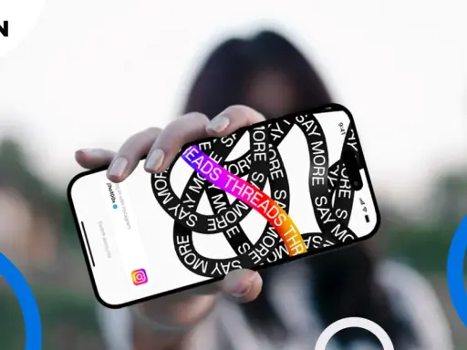 Dłoń trzyma telefon z napisem "THREADS THREADS THREADS" i hasłem "SAY MORE". Aplikacja Threads, co to?