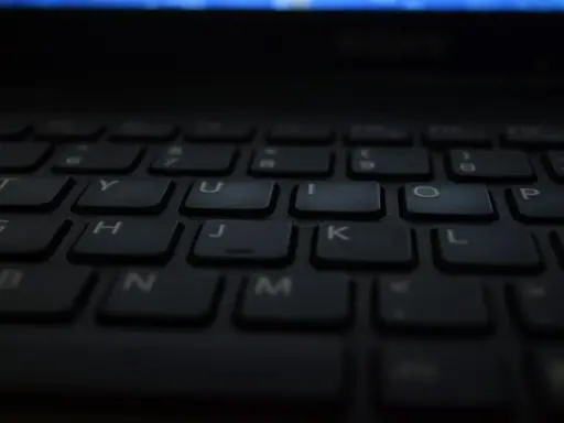 Klawiatura laptopa, gotowa do pisania głosowego w Word. Litery T, Y, U, I, O, P, G, H, J, K, L, B, N, M widoczne.