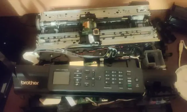 Rozłożona drukarka Brother MFC-J470DW, być może z powodu błędu 48. Widoczne wnętrze, płytki drukowane i kable.