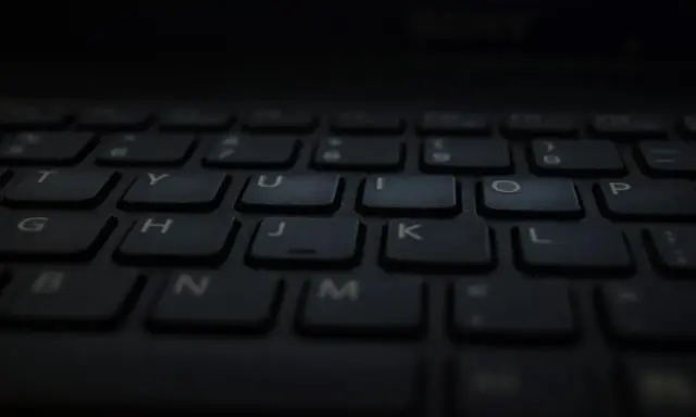 Klawiatura laptopa, gotowa do pisania głosowego w Word. Litery T, Y, U, I, O, P, G, H, J, K, L, B, N, M widoczne.