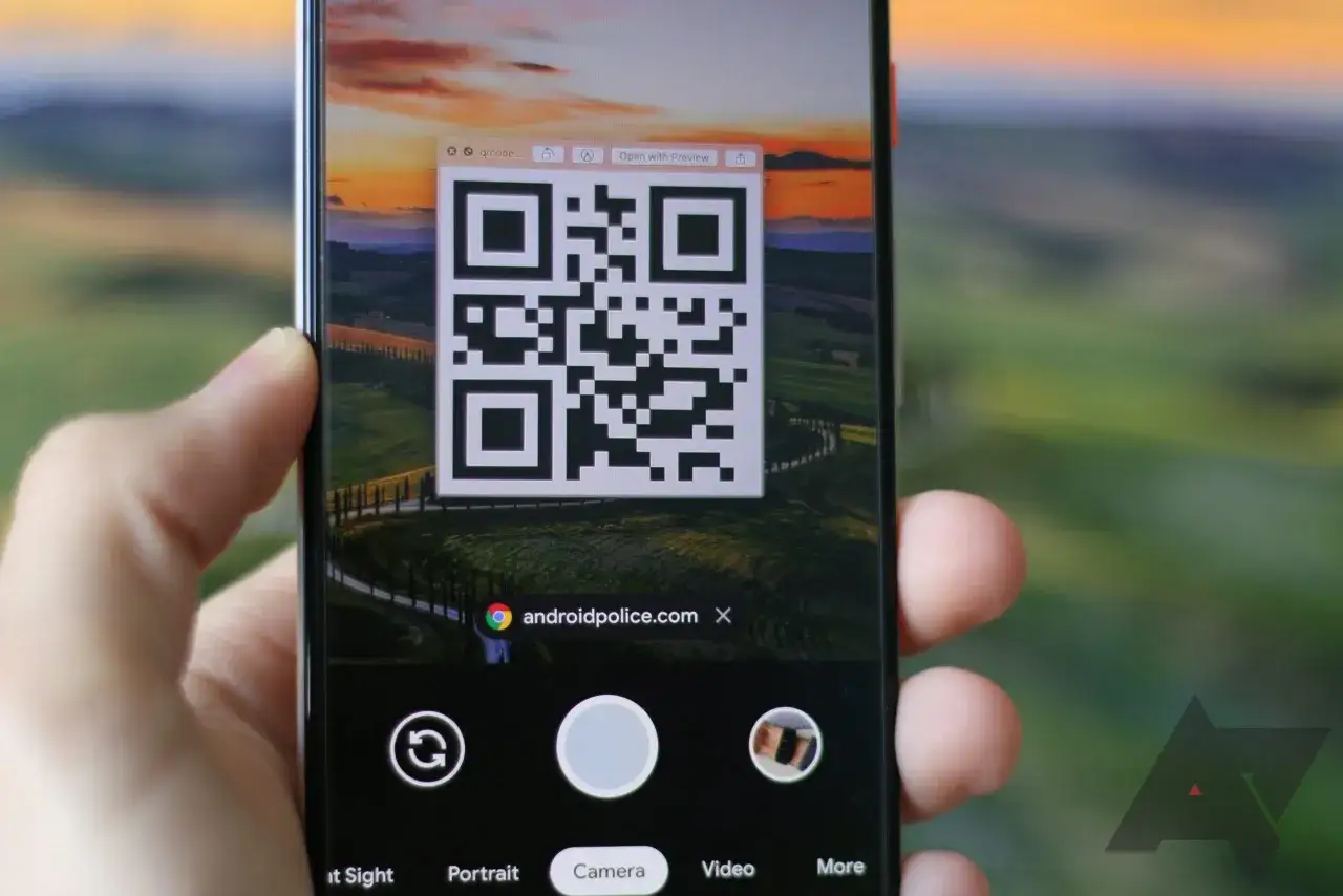 Jak zeskanować kod QR ze zdjęcia? Telefon z aparatem skierowanym na kod QR wyświetlany na ekranie komputera.